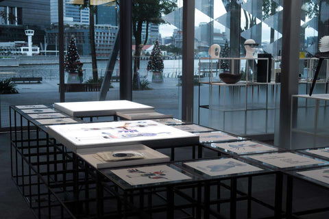 Light table featuring cut-out design character transparencies in an indoor setting, with Marina bay visible through the background