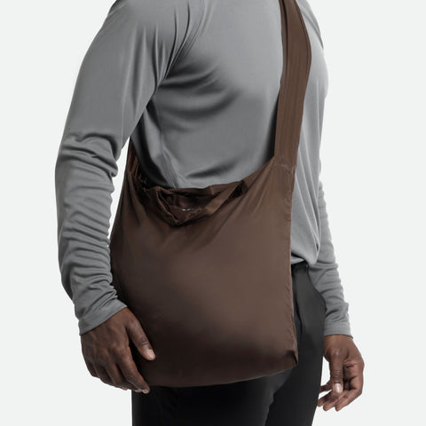 Model using the burnt umber tetra tote bag in a crossbody form