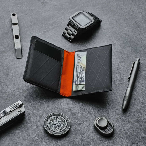 Ark Bifold Wallet X-PAC VX21: Black, opens at center, surrounded by EDC tools—clean layout, bold orange core, built for sleek everyday carry