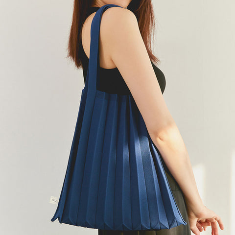 Model wearing the Pleatsmama Shoulder Bag Solid on her shoulder in rich navy color— for a modern everyday look