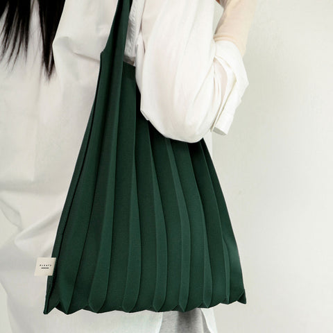 Pleatsmama Shoulder Bag Solid—draped on the shoulder, showcasing rich green pleats and soft texture for a chic, modern everyday look