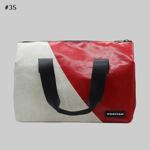 A FREITAG F45 LOIS Sports Bag front image with a striking combination of off-white and vivid red split diagonally, accented with deep black straps and details, giving it a bold, high-contrast and dynamic look