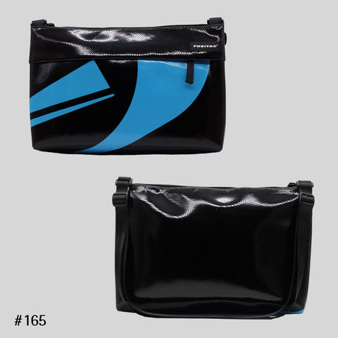 FREITAG F553 LOU shoulder bag in black with blue graphic print, upcycled truck tarp crossbody, front and back views.