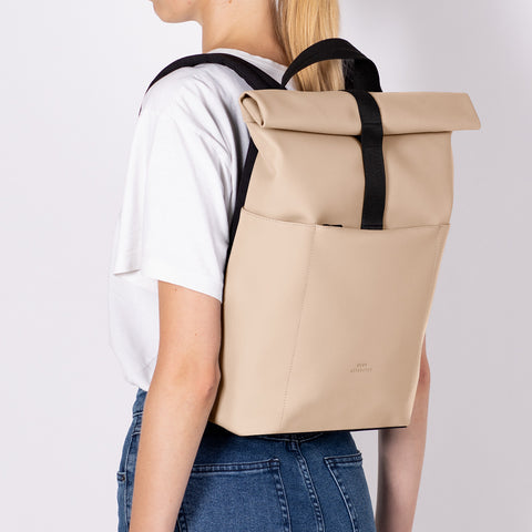 Model carrying Ucon Acrobatics Hajo Mini Backpack Lotus Series with light almond colour with black straps