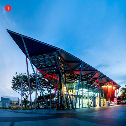 Evening time at Red Dot Design Museum building with glass panel and overhanging roof light up by red and white lighting at Marina bay