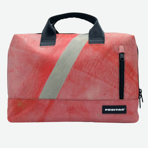 FREITAG F301 MOSS front image of a faded, dusty red base dominates the bag, with natural variations that give it a worn, slightly weathered character. A muted light grey stripe cuts diagonally across, softening the overall look, while black handles, zipper details, and label add a strong, functional contrast.
