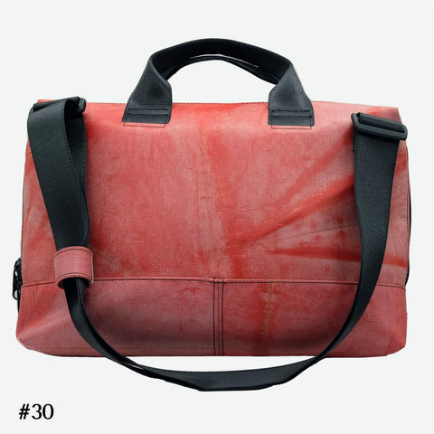 FREITAG F301 MOSS back view image of a muted, weathered red body defines the bag, with subtle tonal variations and scuffs that give it a slightly rugged, worn-in character. The look is grounded by deep black straps, handles, and hardware, creating a bold contrast against the softened red surface
