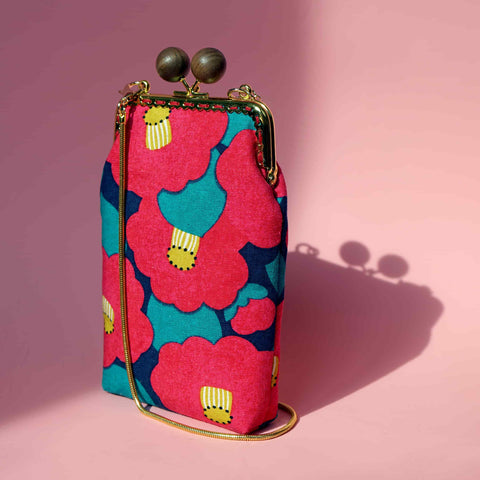 Cocoonese Cell Phone Purse-Camellia Japonica—vibrant floral hues on pink, captured in a sleek angled shot that highlights its chic, compact elegance