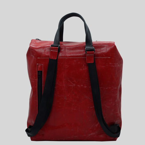 Back view of FREITAG F201 PETE backpack in red with black straps, black handles, a zip pocket.