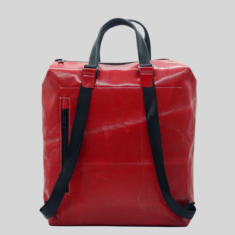 Back view of FREITAG F201 PETE backpack in bright red with black straps, black handles and a zip pocket.