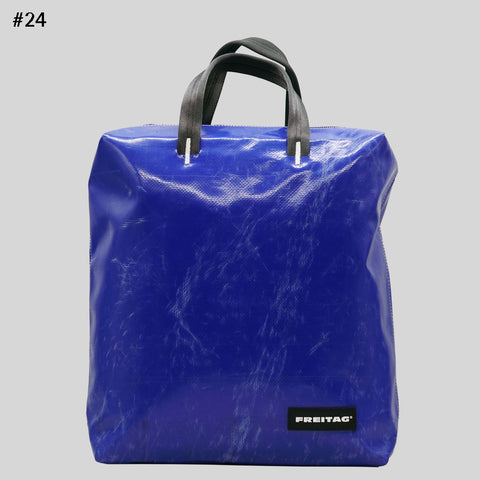 Front view of FREITAG F201 PETE backpack in blue with black handles, scratched surface.