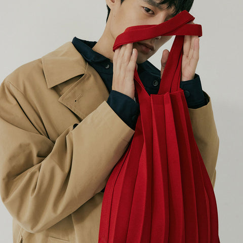 Pleatsmama Shoulder Bag Solid in red, soft textured pleats drape elegantly as the model frames it up close for a bold, stylish statement