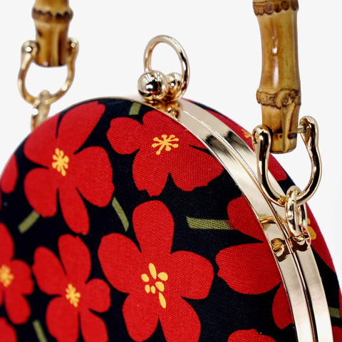Close up view of Cocoonese Round Hard Case Bamboo Handle Bag of its brass plated electroplating alloys frames giving it a nice shine