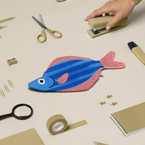 Don Fisher Seabass fish case with a sea of scissors, notepad, pencils, glasses, tape, stapler, small items which can be fit into the case