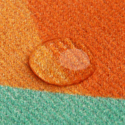 Close-up of Don Fisher Soldier Backpack-Orange fabric shows textured cotton with a water droplet beading on its surface