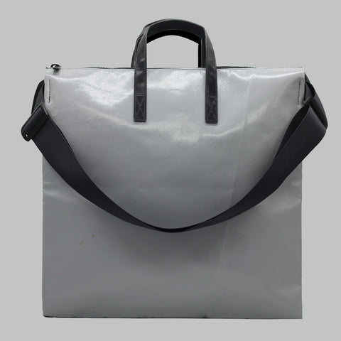 FREITAG F275 TILDA back view with shoulder strap shown and in light grey color with a slightly reflective, glossy finish, suggesting a coated, water-resistant material like tarpaulin. The surface shows natural creases and subtle texture, giving it an industrial, used-yet-durable character
