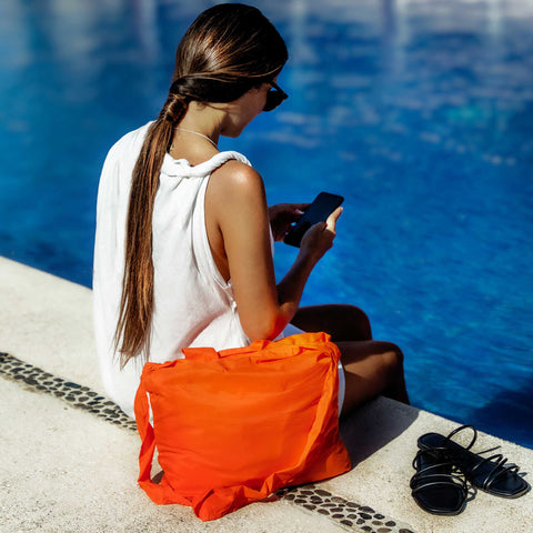 Model utilising a torii orange Tetra tote bag in an outdoor setting