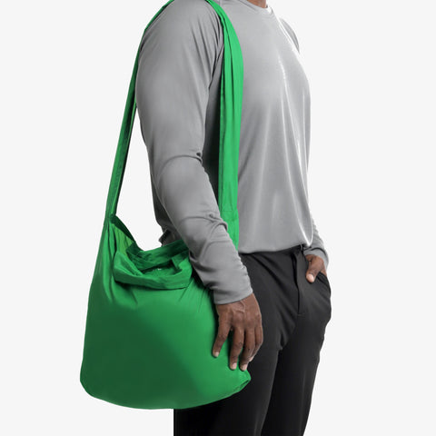 Model using the viridian green tetra tote bag in a on shoulder form