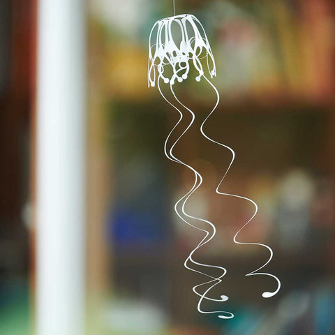 Finished piece of KURUKURU Wind Jelly Fish Hanging, slanted angle view against a blurred interior background, by Fukunaga Print Co., Ltd
