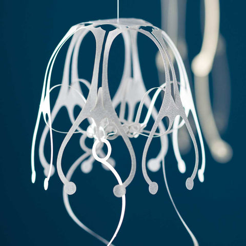 Close-up angled view of KURUKURU Wind Jelly Fish Hanging, with a second piece blurred in the background, by Fukunaga Print Co., Ltd