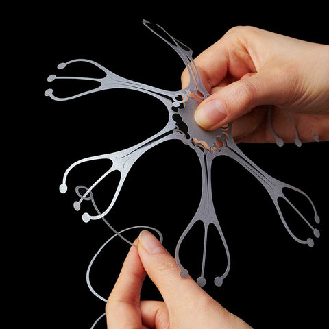 A pair of hands holding a paper cut-out pattern of a Wind Jelly Fish Hanging called KURUKURU by Fukunaga Print Co., Ltd