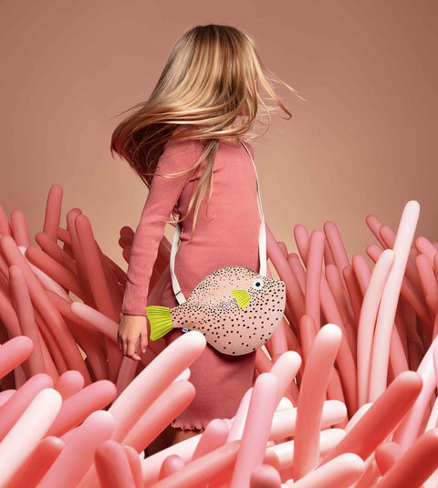 Model twirls with the Don Fisher Pufferfish Shoulder Bag-Pink, adding fun, charm, and personality to every little adventure