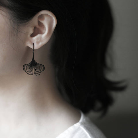 Model wears Moorigin Stainless Steel Earrings-Ginkgo S Black, sleek ginkgo drops adding a subtle, modern and elegant touch to her look
