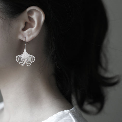 Model wears Moorigin Stainless Steel Earrings-Ginkgo S Silver, delicate ginkgo drops swaying softly, adding a light, elegant touch to her look