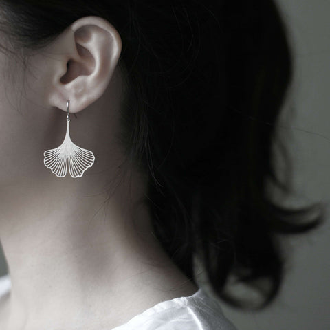 Model wears Moorigin Stainless Steel Earrings-Ginkgo S Silver, delicate ginkgo drops swaying softly, adding a light, elegant touch to her look