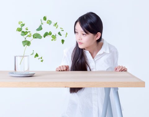 A model viewing the floating effect of a leaf plant place in Shallows crystal glass vase