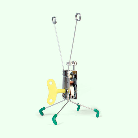 Kikkerland Wind Up Toy-Cranky features a sleek metal body, bright yellow key, and green feet—watch it spring to life with quirky, kinetic motion