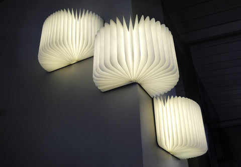 Lumio Lito book lamp brightly lit in a dark setting which also showcase the book magnetic surface when place on a 90 degree angle