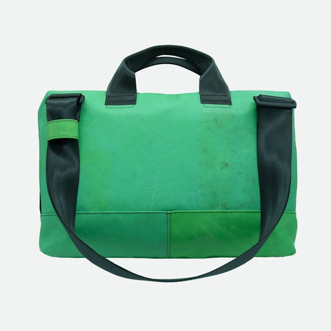 FREITAG F301 MOSS back view image with a rich, slightly muted green body forms the main color, with subtle variations and wear giving it a softer, lived-in look. This is contrasted by deep black straps, handles, and hardware, creating a clean, utilitarian contrast against the green base.