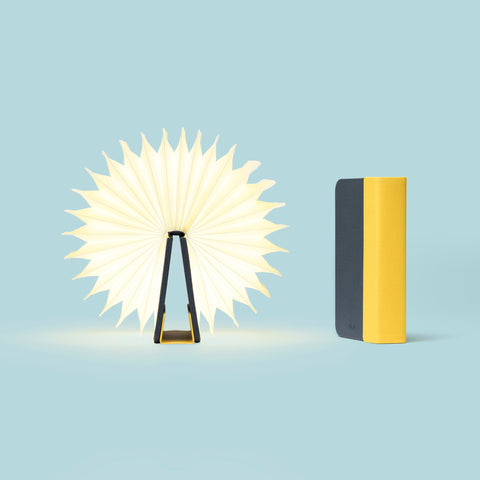 Lumio Lito Mini, a portable and foldable yellow and blue book lamp, It acts as a power bank and a lamp which can be open up to 360 degrees