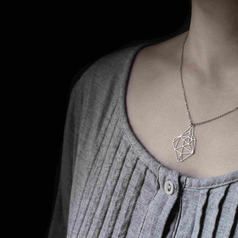 Model wears the Moorigin Stainless Steel Pendant - Silver S at mid-chest, its delicate geometric form complementing a soft, neutral outfit