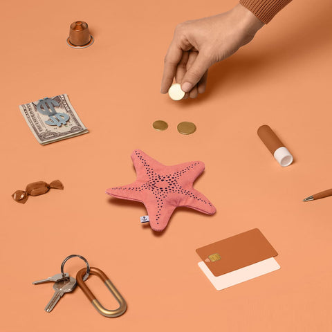 Don Fisher pink starfish purse with a sea of keys, cards, sweets, cash, coins, limp bum, small items which can be fit into the purse