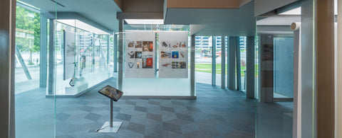 Indoor event and exhibition space with glass walls and displayed items