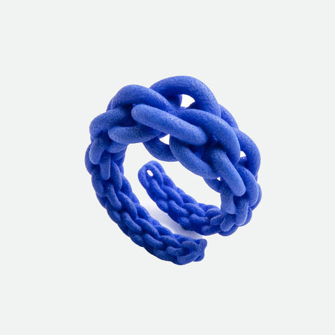 A 3D-printed 'Magna' ring by Maison 203 in vibrant blue. The design is braided chain.