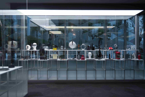 Product design exhibition on display inside a glass panel with Marina bay as background