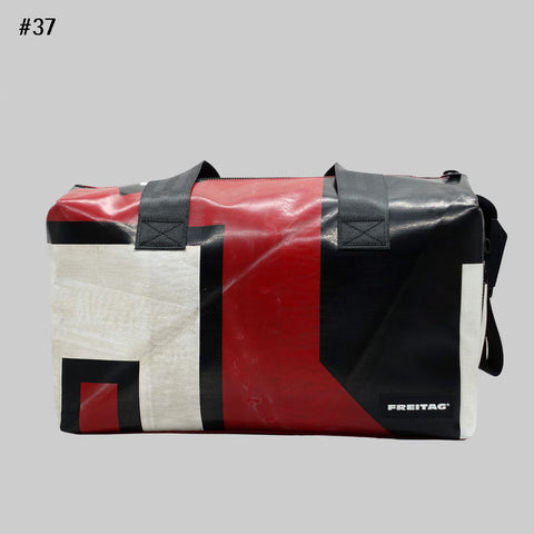 Front view of FREITAG F45 LOIS sports bag with black handles, red, black and off-white.
