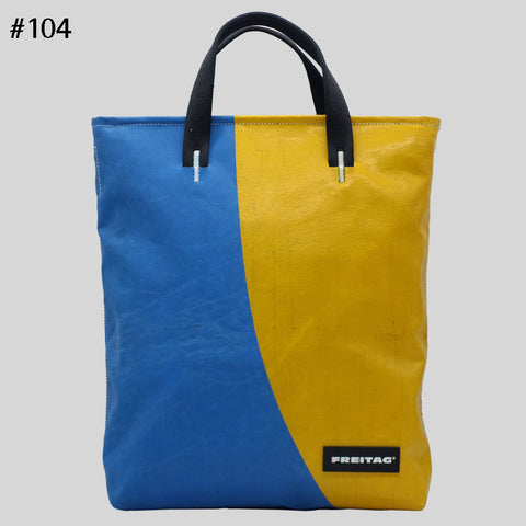 Front view of FREITAG F202 LELAND tote bag with black handles, blue and yellow panels.