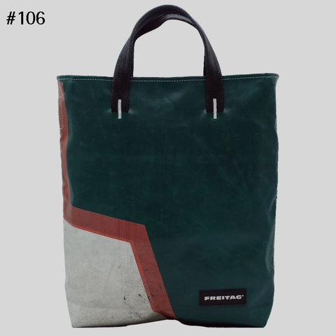 Front view of FREITAG F202 LELAND tote bag with black handles, dark green, pink and white. 