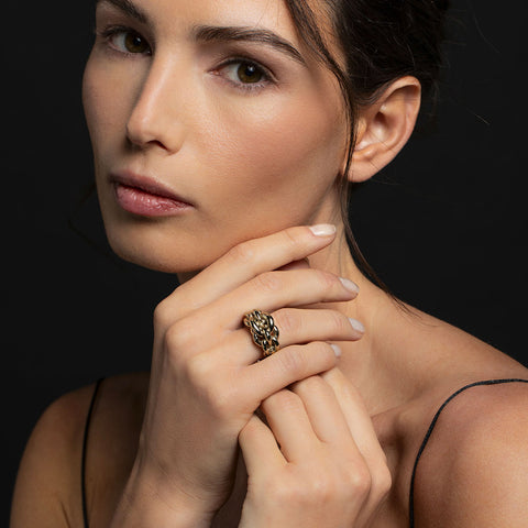 Model wearing the gold Magna ring which embodies the oversized forms and concept of chains into a sculptural and distinctive jewel
