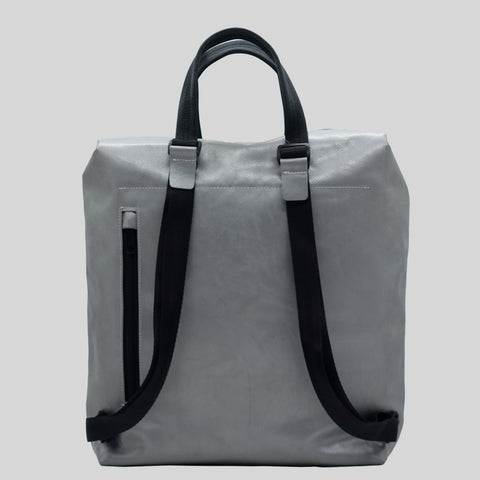 Back view of FREITAG F201 PETE backpack in silver with black handles and a zip pocket.