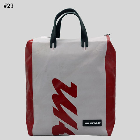 Front view of FREITAG F201 PETE backpack in white a.nd red with black handles and red lettering.