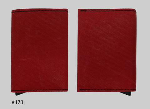Front and back views of red FREITAG F705 SECRID Slimwallet RFID wallet with black stitching and a metal card slider at the base.