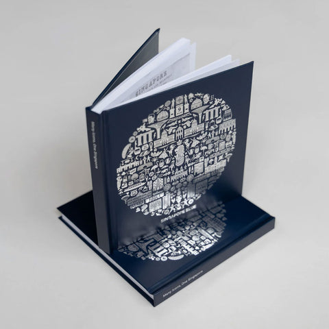 Blue book with glossy silver graphic print design on a grey background