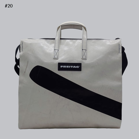 Front view of FREITAG F275 TILDA tote bag in white and black, with white handles and diagonal black stripe