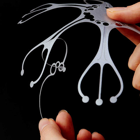 A close-up side view of a pair of hands holding a cut-out pattern of a Wind Jelly Fish Hanging, KURUKURU, by Fukunaga Print Co., Ltd